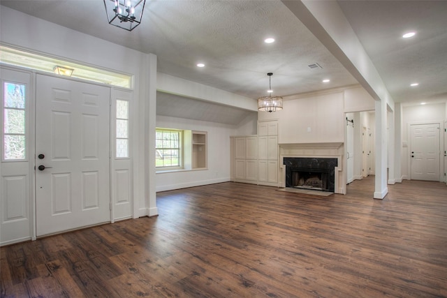 83 Dahlia Rd, Huntsville, TX 77320 - entrance foyer with visible vents, baseboards, an inviting chandelier, dark wood-style floors, and lofted ceiling