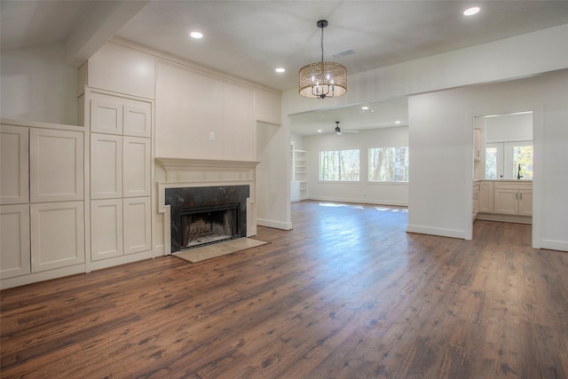 83 Dahlia Rd, Huntsville, TX 77320 - unfurnished living room featuring ceiling fan with notable chandelier, recessed lighting, a premium fireplace, baseboards, and dark wood-style floors
