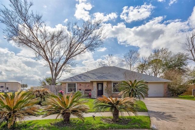 ranch-style home with brick siding, an attached garage, fence, and concrete driveway