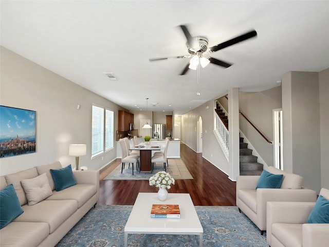 12223 Forstall Dr, Houston, TX 77014 - living room featuring stairway, ceiling fan, dark wood finished floors, baseboards, and visible vents
