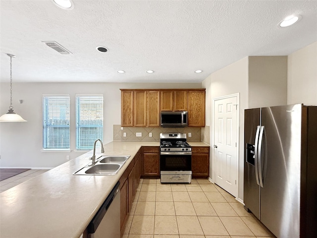 12223 Forstall Dr, Houston, TX 77014 - kitchen featuring stainless steel appliances, a sink, visible vents, brown cabinetry, and light tile patterned floors
