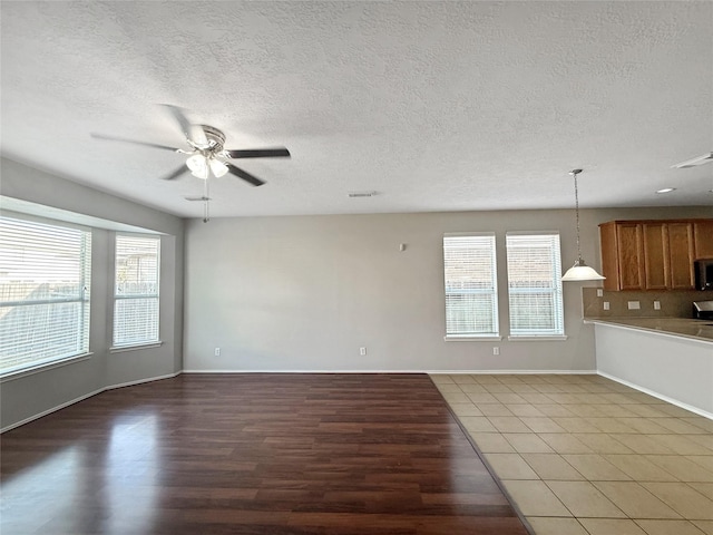 12223 Forstall Dr, Houston, TX 77014 - unfurnished living room featuring light wood finished floors, a ceiling fan, and a textured ceiling