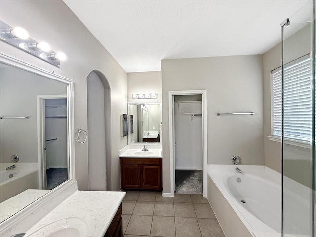 12223 Forstall Dr, Houston, TX 77014 - bathroom with a spacious closet, a garden tub, tile patterned floors, and vanity