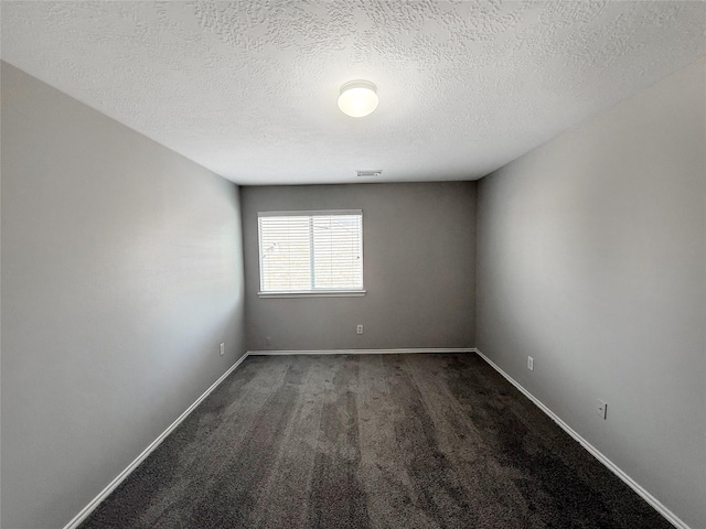 12223 Forstall Dr, Houston, TX 77014 - unfurnished room with baseboards, visible vents, dark carpet, and a textured ceiling