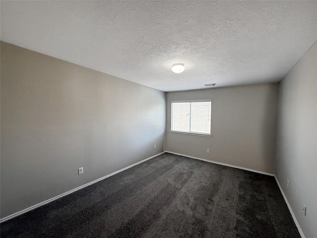 12223 Forstall Dr, Houston, TX 77014 - empty room with a textured ceiling, dark colored carpet, visible vents, and baseboards