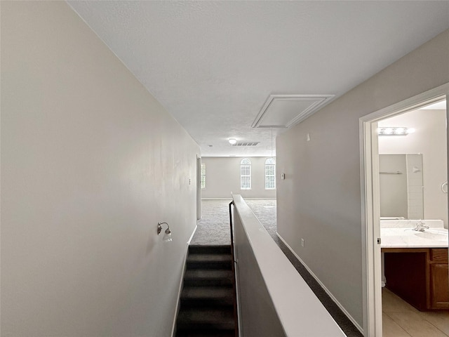 12223 Forstall Dr, Houston, TX 77014 - corridor with attic access, light carpet, baseboards, and light tile patterned floors