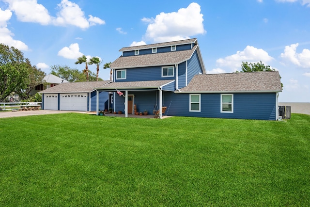 traditional-style house featuring an attached garage, a front lawn, and driveway