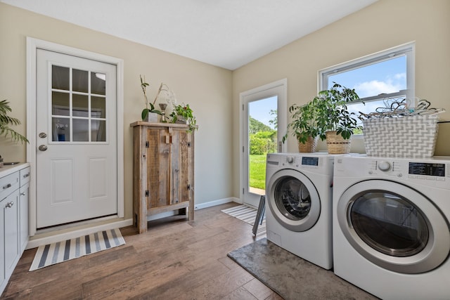 clothes washing area featuring baseboards, light wood finished floors, laundry area, and separate washer and dryer