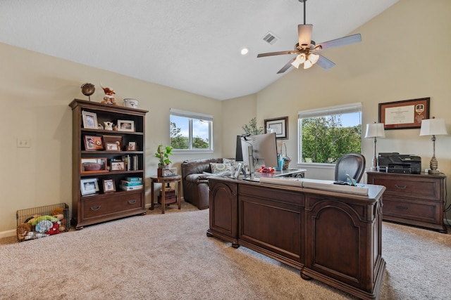 office featuring light carpet, lofted ceiling, visible vents, and plenty of natural light