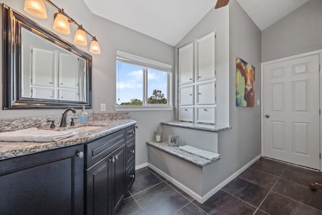 bathroom featuring baseboards, lofted ceiling, tile patterned flooring, and vanity