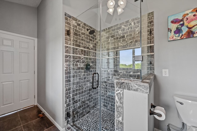 bathroom with toilet, tile patterned flooring, and a stall shower
