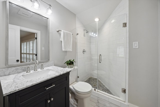 full bath with vanity, tile patterned floors, toilet, a stall shower, and vaulted ceiling