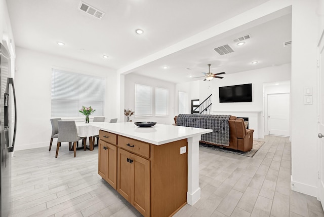 kitchen with a fireplace, light wood-style floors, and visible vents