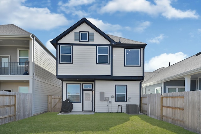 rear view of property featuring a lawn, a fenced backyard, and central AC unit