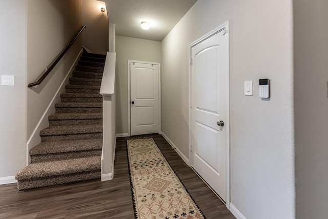 interior space featuring stairway, baseboards, and dark wood-style floors