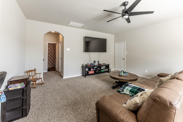 carpeted living room with arched walkways, visible vents, a ceiling fan, and baseboards