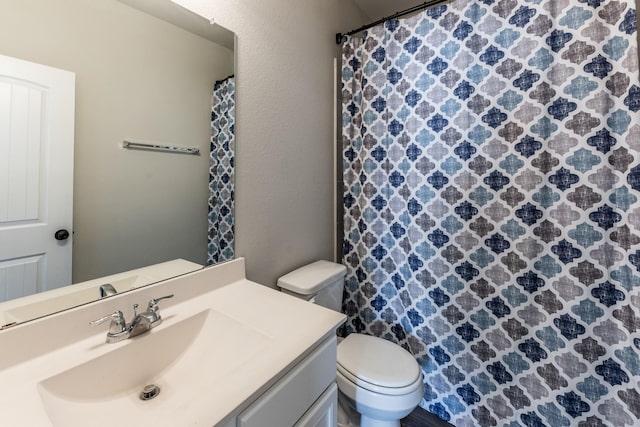 bathroom with a shower with shower curtain, toilet, and vanity