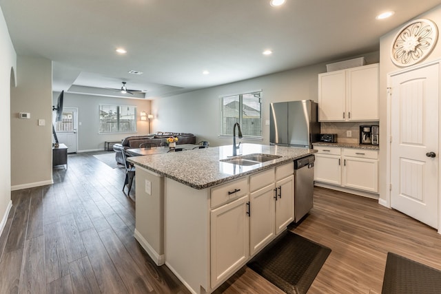kitchen featuring white cabinets, stainless steel appliances, a sink, and a wealth of natural light