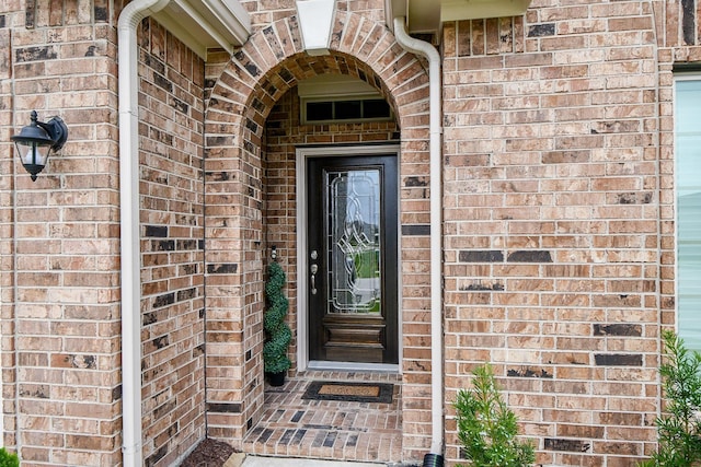 property entrance featuring brick siding
