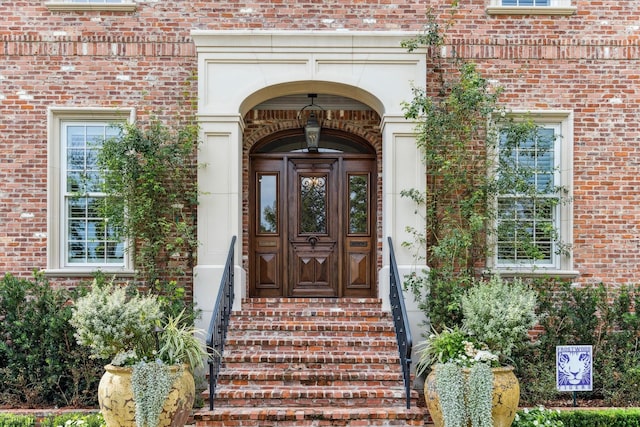 view of exterior entry with brick siding