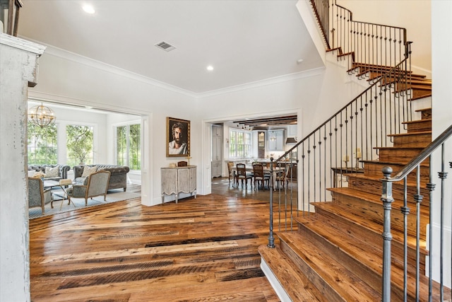foyer with wood finished floors, stairway, crown molding, recessed lighting, and a chandelier