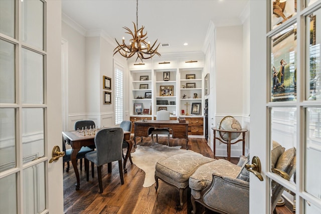 office space featuring a chandelier, dark wood-style floors, ornamental molding, a wainscoted wall, and a decorative wall