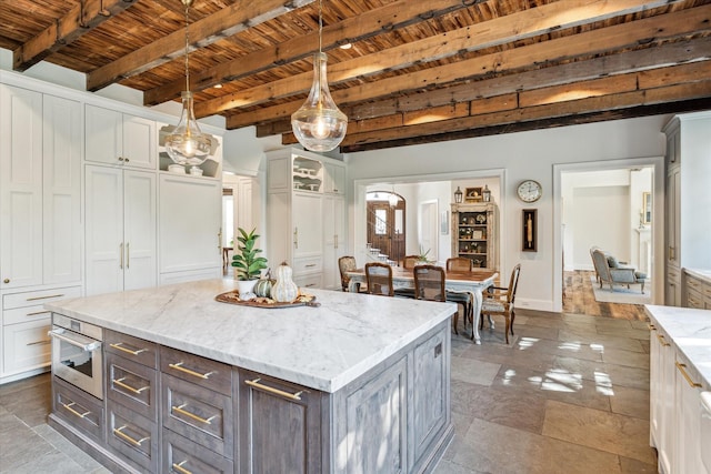 kitchen featuring wooden ceiling, beamed ceiling, white cabinetry, pendant lighting, and light stone countertops