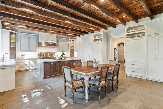 dining space with wood ceiling, beamed ceiling, and stone tile floors