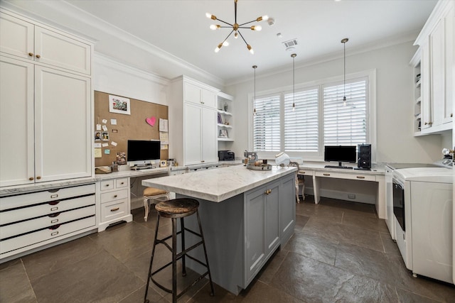 kitchen featuring open shelves, crown molding, washing machine and dryer, a center island, and a breakfast bar