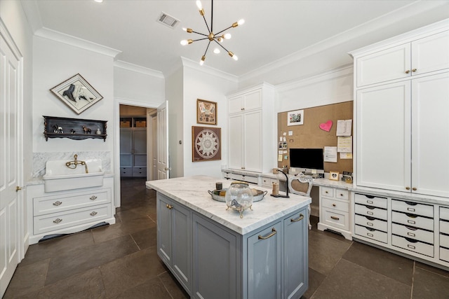 kitchen with crown molding, a chandelier, a center island, white cabinetry, and light stone countertops