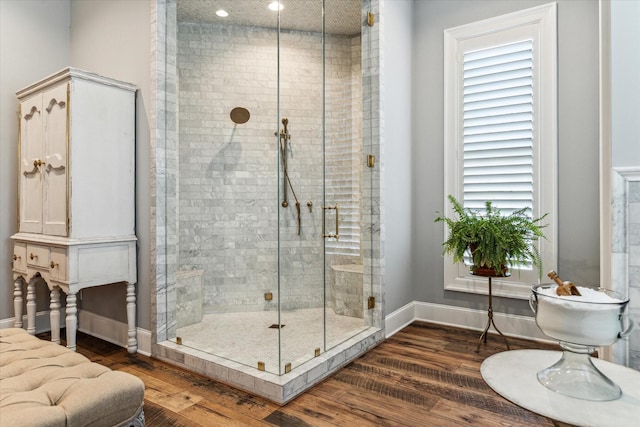 bathroom featuring a stall shower, baseboards, wood finished floors, and recessed lighting