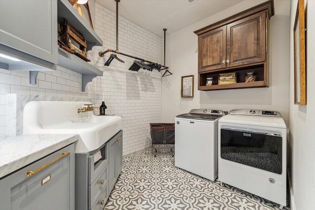 laundry area featuring cabinet space, separate washer and dryer, and light tile patterned floors