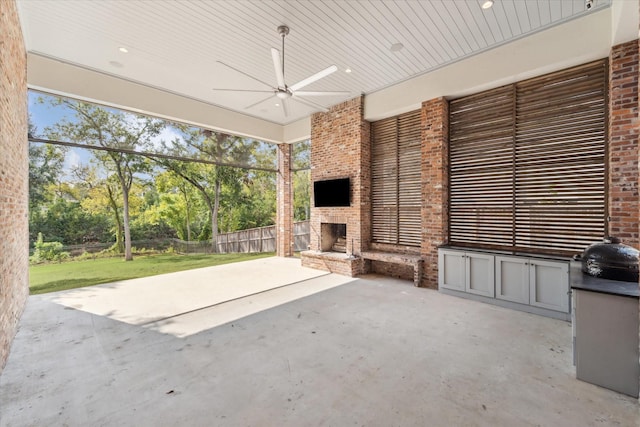 view of patio / terrace featuring a large fireplace and ceiling fan
