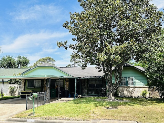 view of front of home with brick siding, a carport, fence, and a front yard