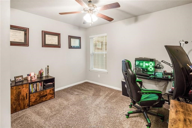 carpeted office space featuring baseboards and ceiling fan