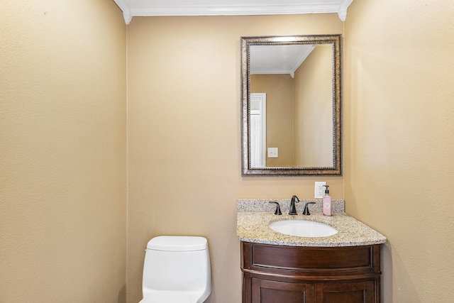 half bathroom with toilet, vanity, and ornamental molding