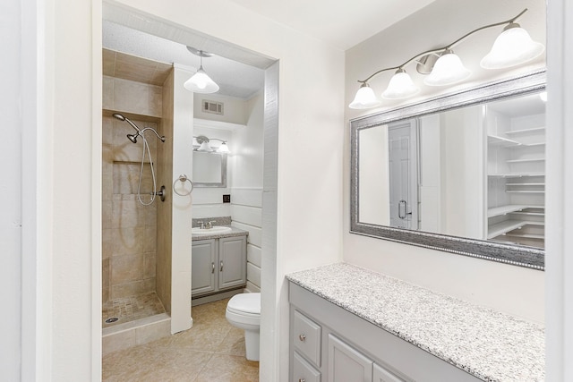 full bathroom with a shower stall, tile patterned floors, visible vents, toilet, and vanity