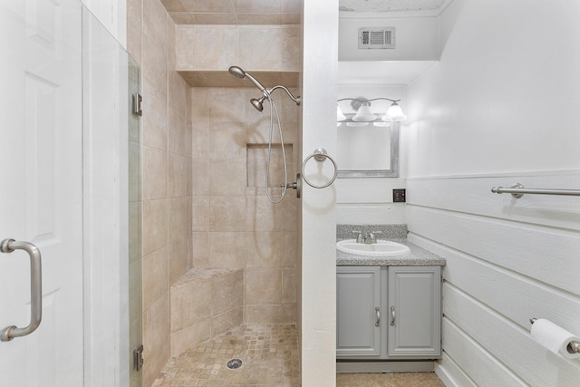 bathroom with visible vents, vanity, a stall shower, and a wainscoted wall