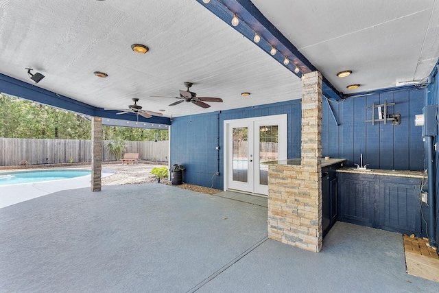 view of patio / terrace featuring a fenced backyard, a ceiling fan, and french doors