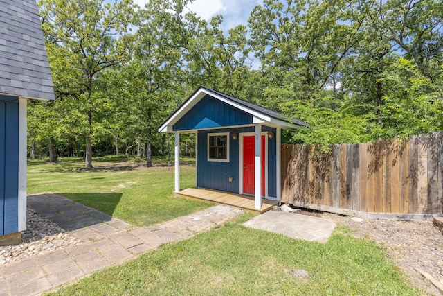 view of outdoor structure featuring fence and an outbuilding