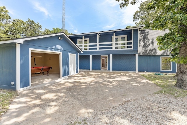 mid-century inspired home with a balcony, an outbuilding, and a detached garage