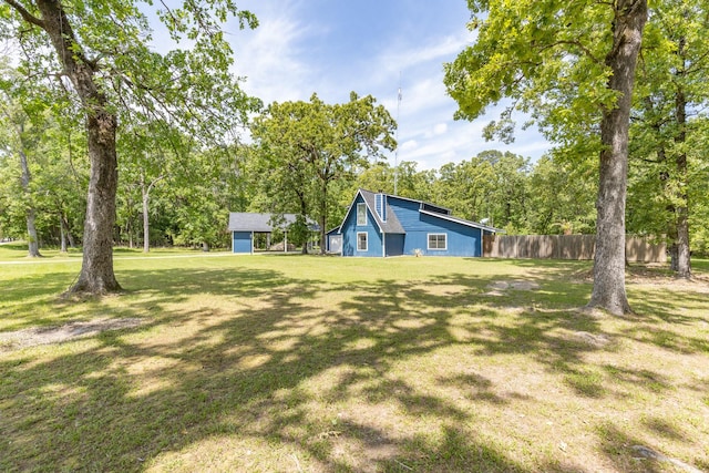 view of yard featuring fence and an outbuilding