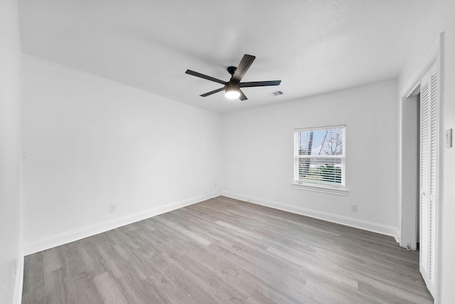 unfurnished bedroom with visible vents, baseboards, a ceiling fan, wood finished floors, and a closet