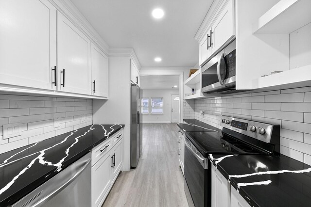 kitchen with white cabinets, dark countertops, light wood-style flooring, and appliances with stainless steel finishes