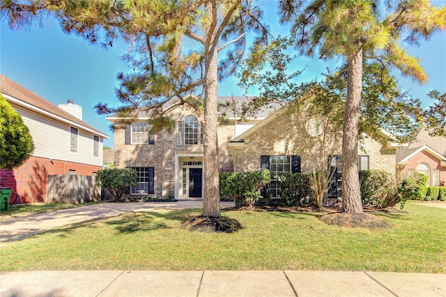 view of front of home with brick siding and a front yard