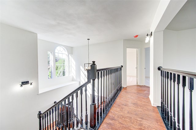hallway with wood finished floors and an upstairs landing