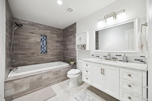 bathroom with tile patterned floors, tiled shower / bath, visible vents, toilet, and vanity