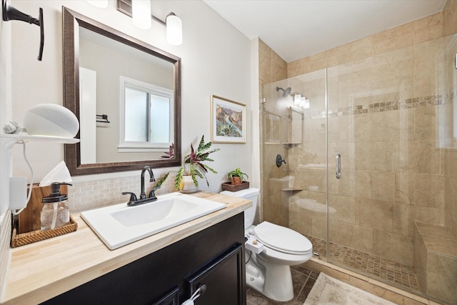 bathroom featuring a shower stall, tile patterned floors, vanity, backsplash, and toilet
