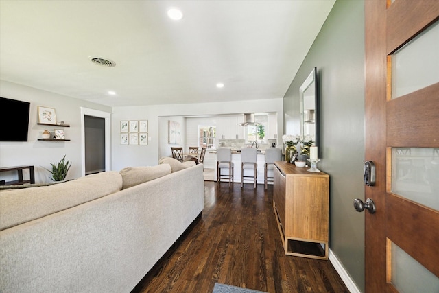 living area with visible vents, wood finished floors, and recessed lighting