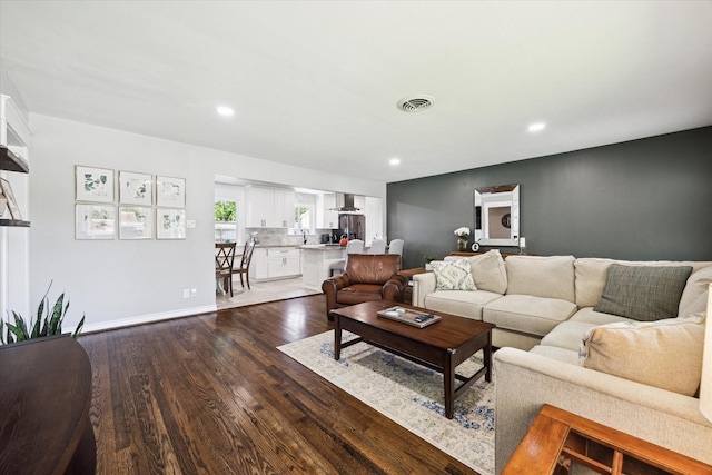 living area with baseboards, dark wood-type flooring, visible vents, and recessed lighting